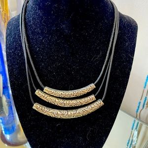 Black necklace with silver metal accent.